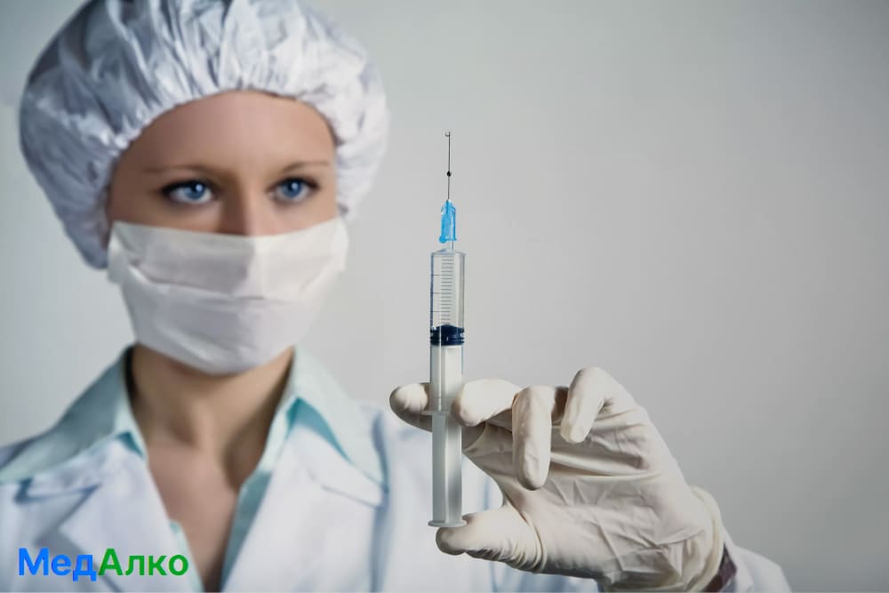 Врач со шприцем в клинике "МедАлко"